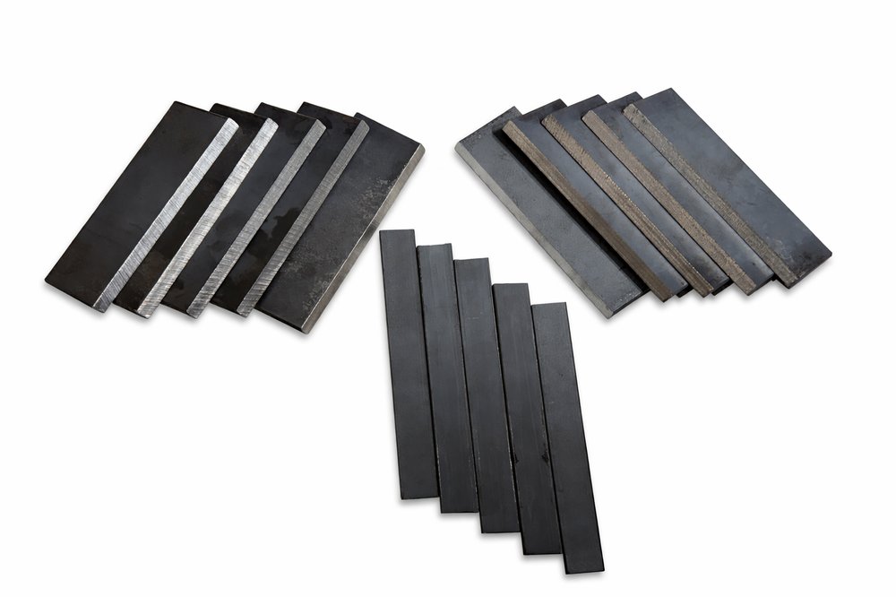 TitanCert welding coupon sets fanned out — plates, backing strips and practice coupons
